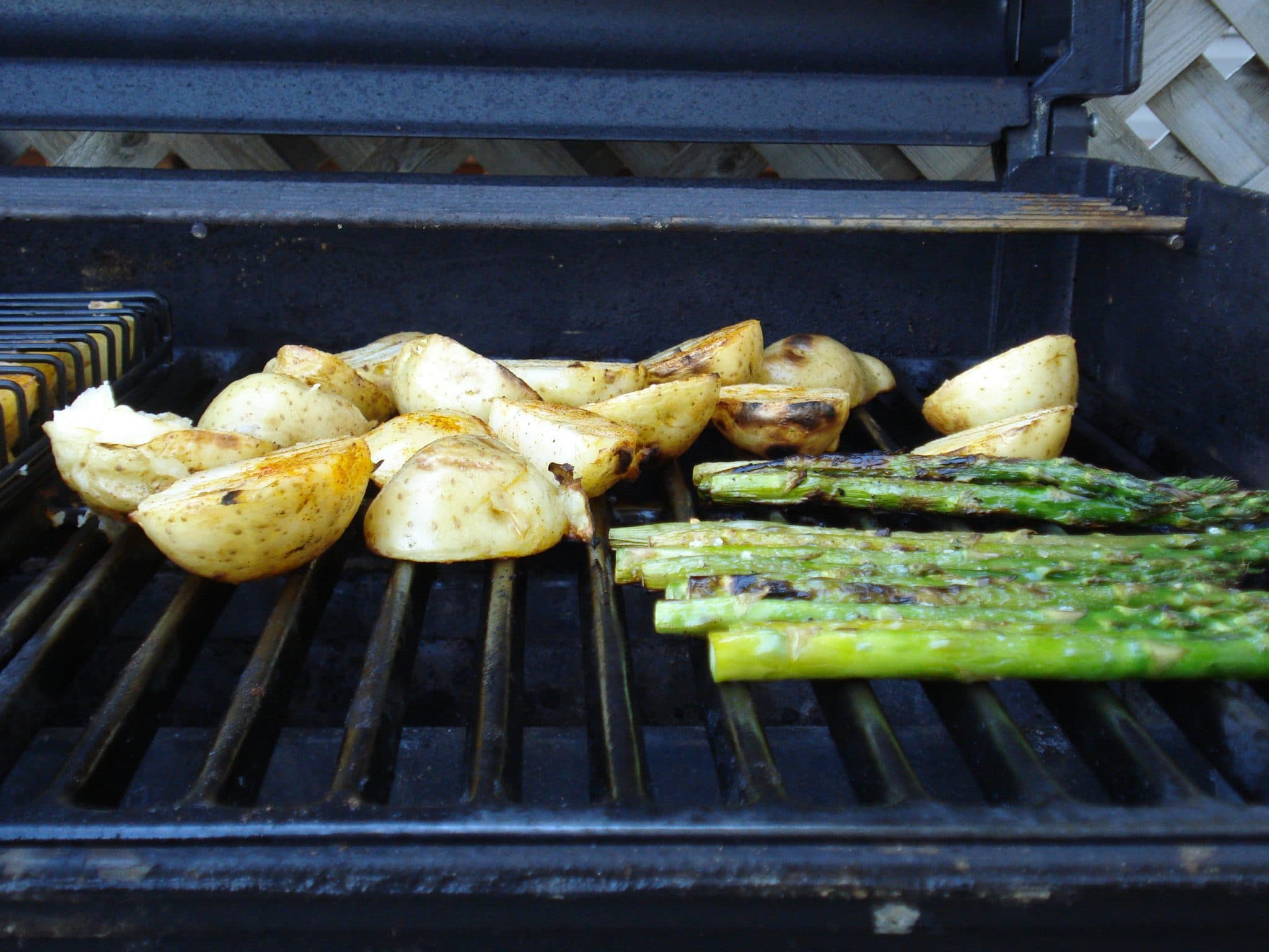 Sliced potato and asparagus on grill