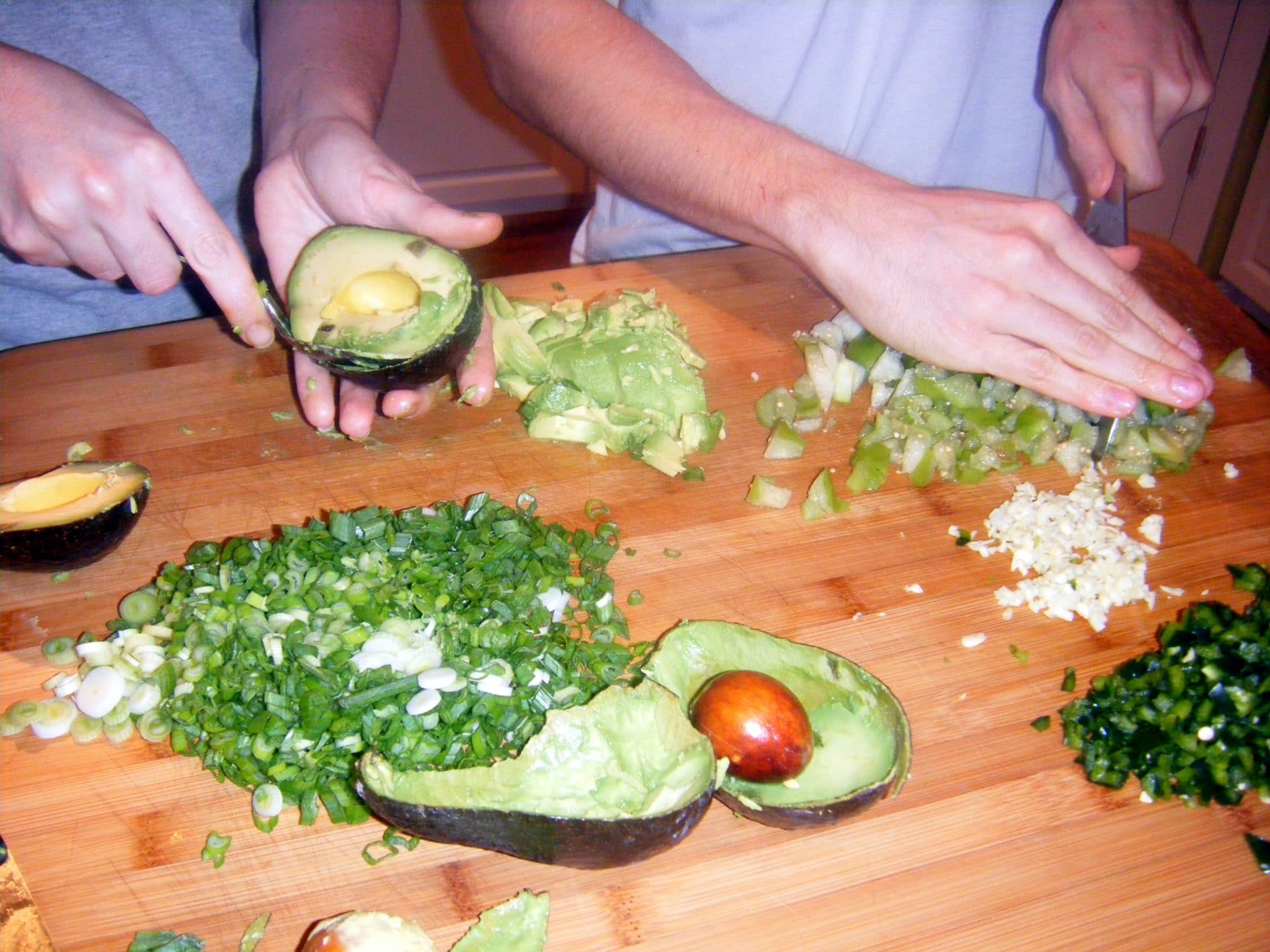 2 sets of hands chopping ingredients