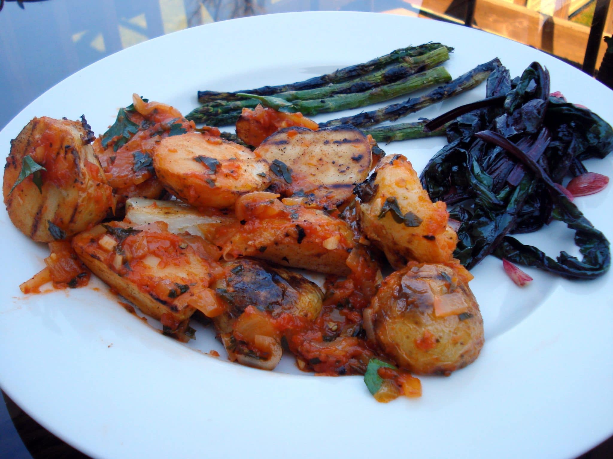 Patatas Bravas and grilled asparagus on plate