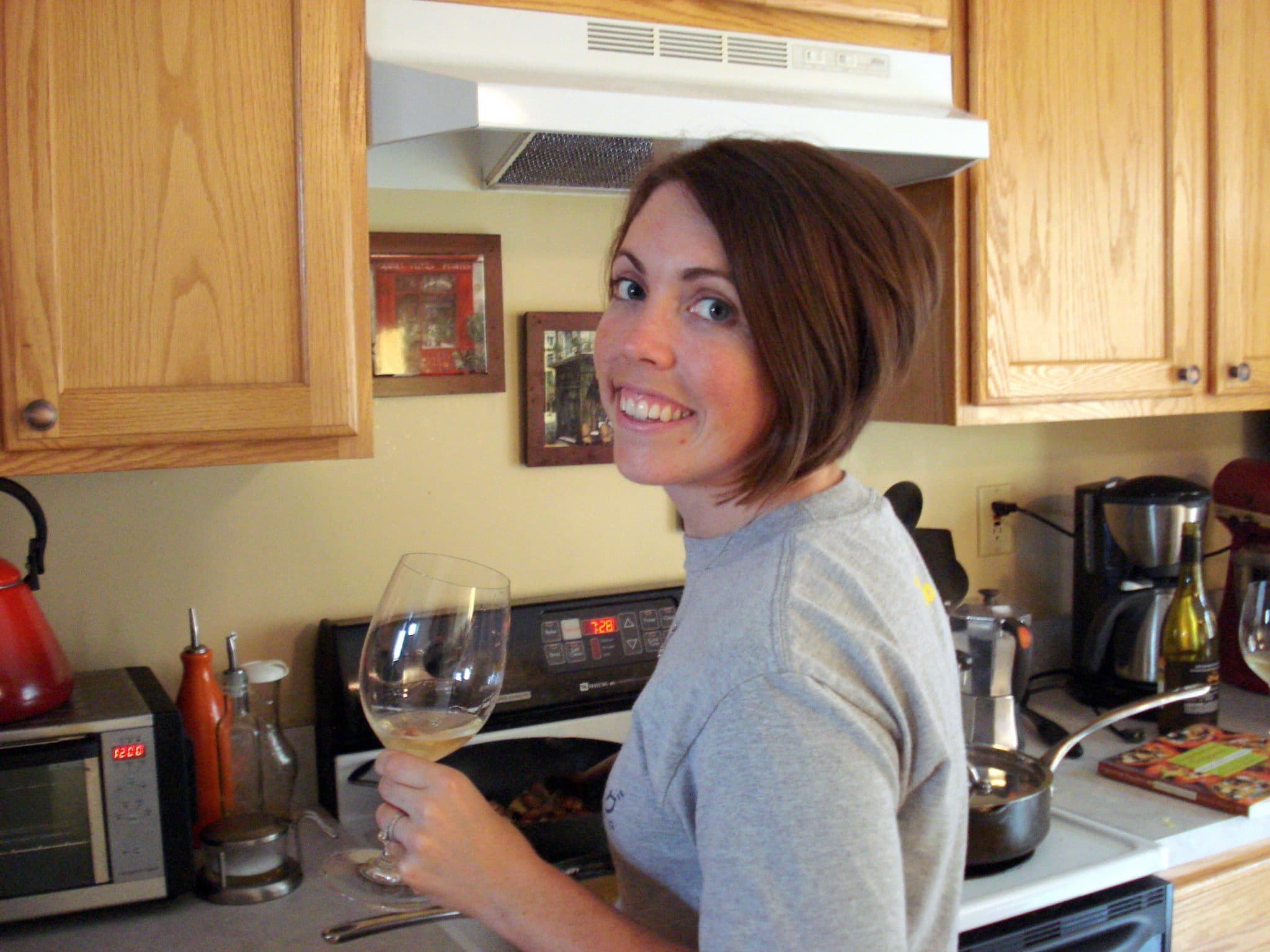 Woman cooking drinking wine