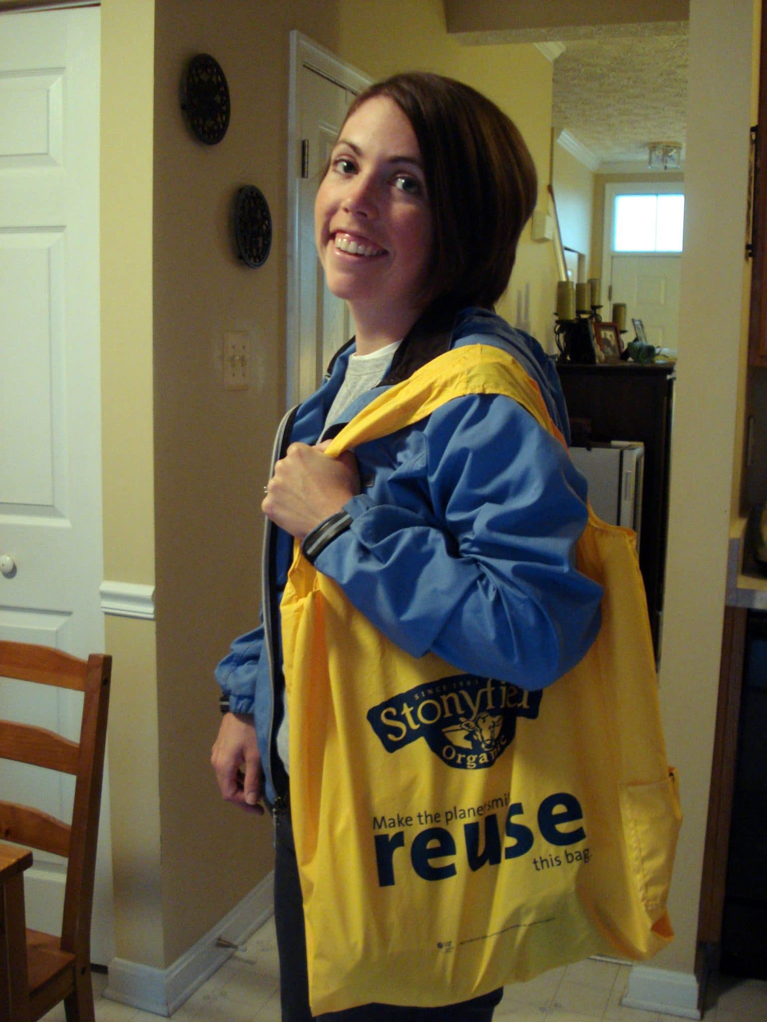 Woman holding yellow Stonyfield reusable tote