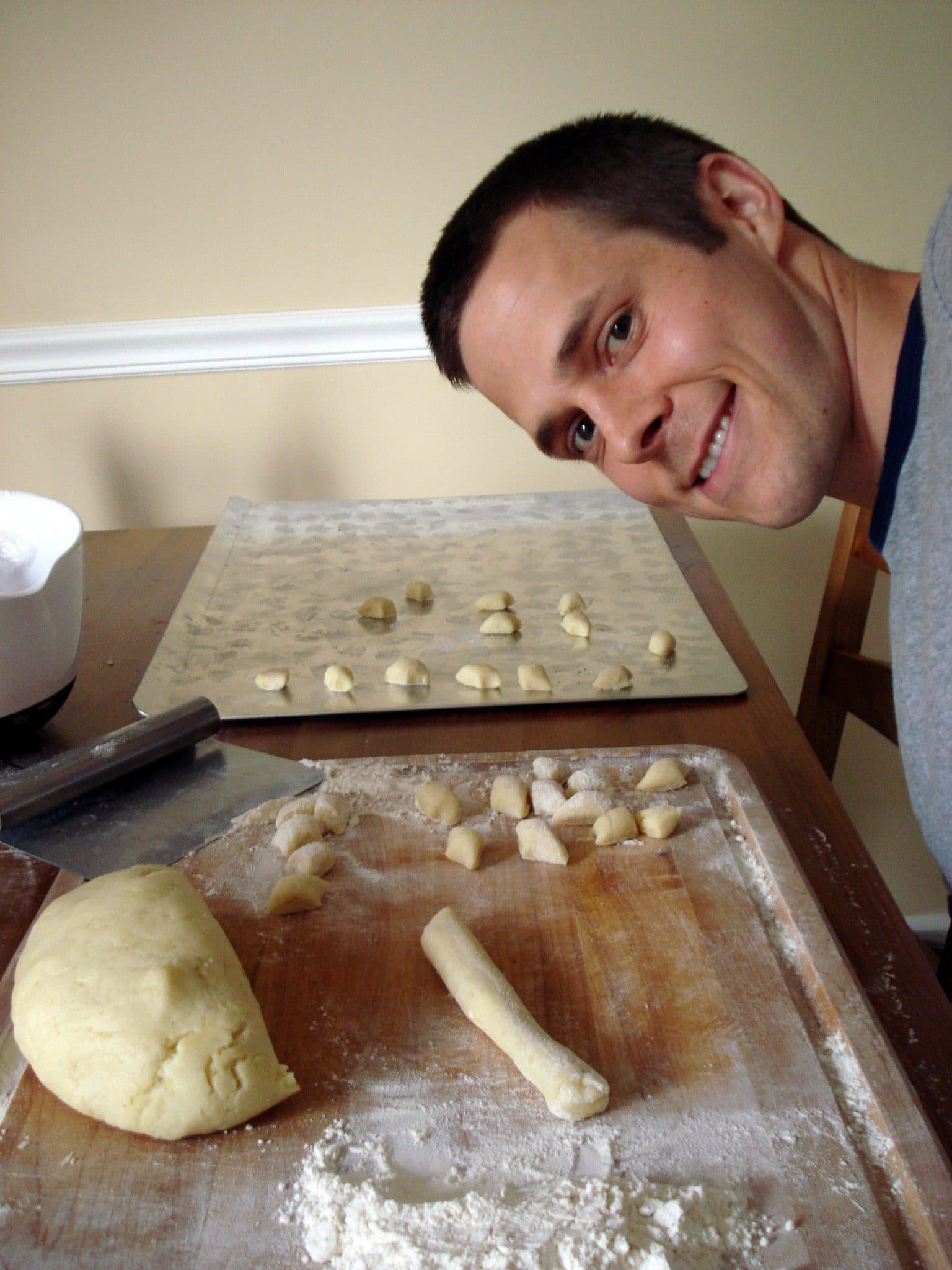 Matt cutting each gnocchi, rolling in flour, and placing on baking sheet