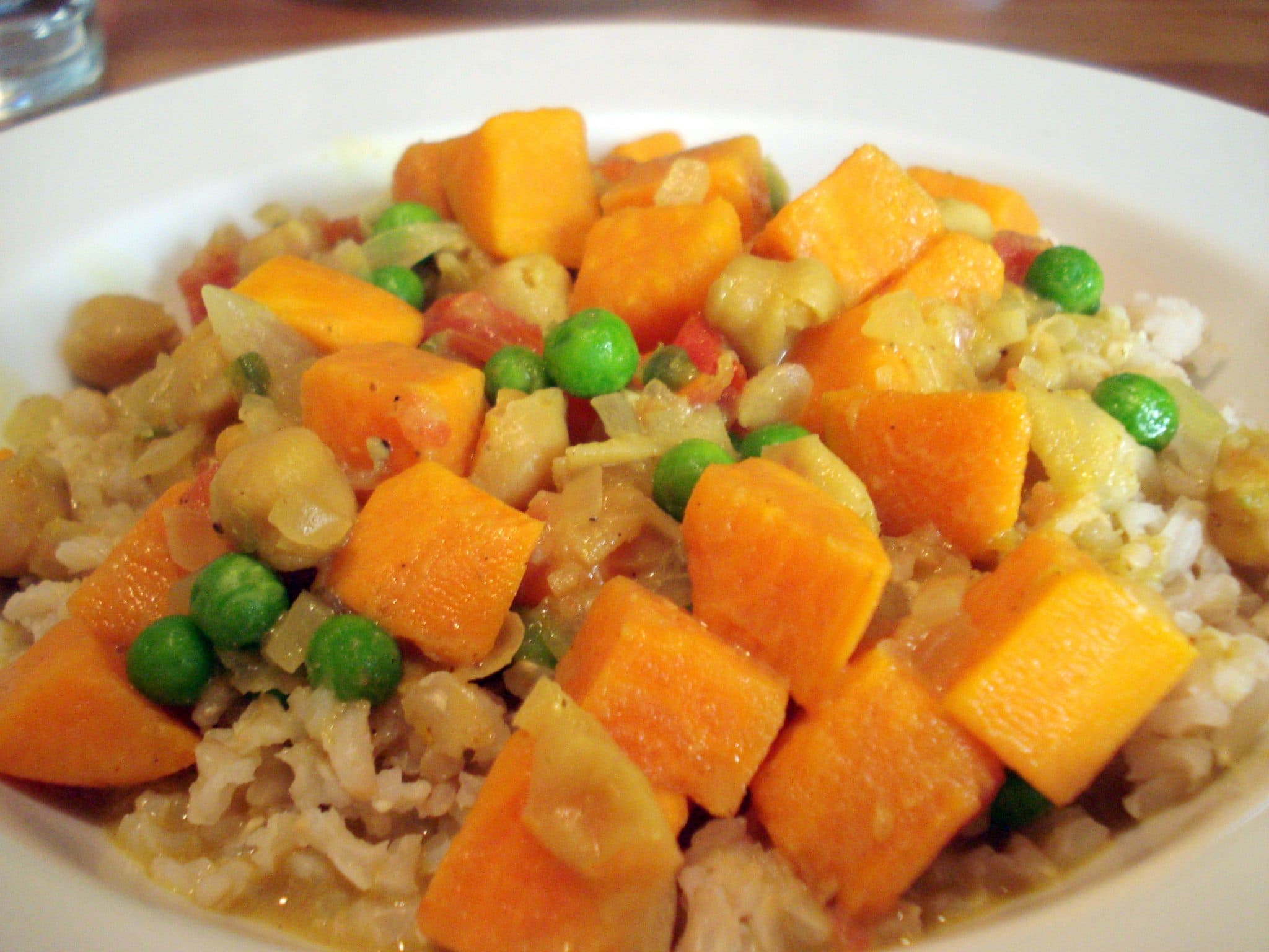 Bowl of Sweet Potato and Chickpea Curry with Green Peas over rice