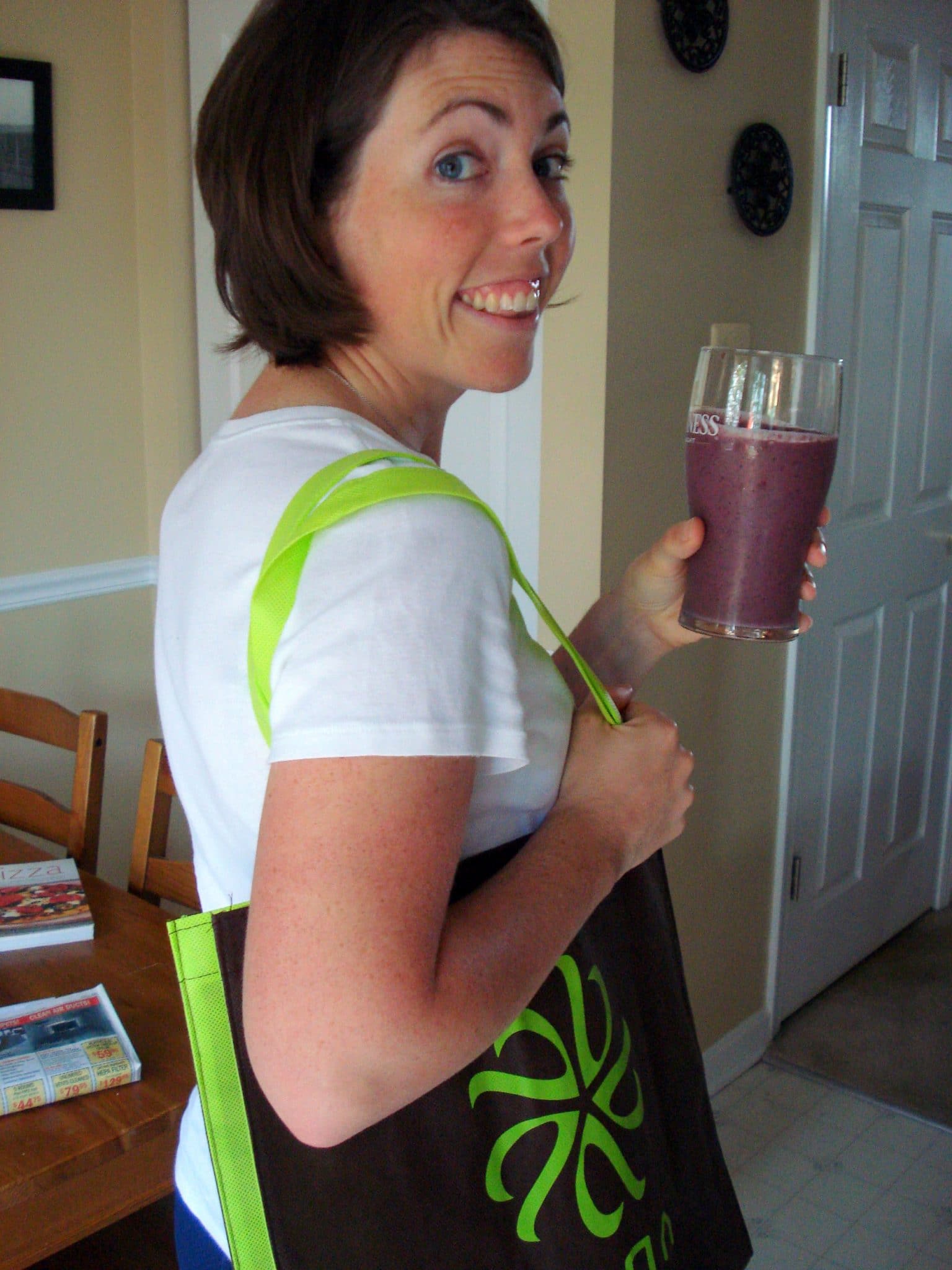 Woman holding Vega tote, drinking Vega smoothie