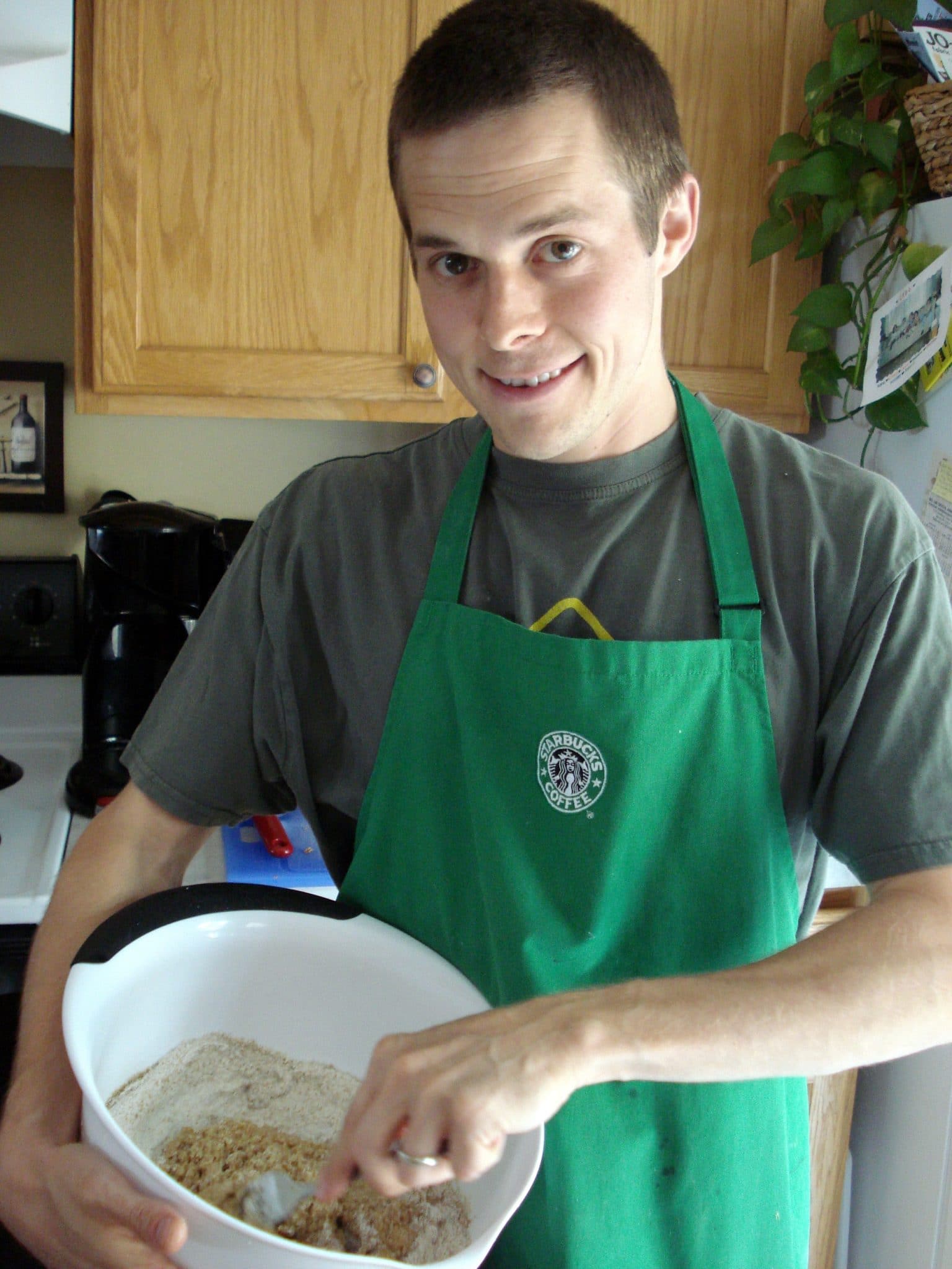 Matt, wearing apron, mixing dry ingredients for homemade pasta