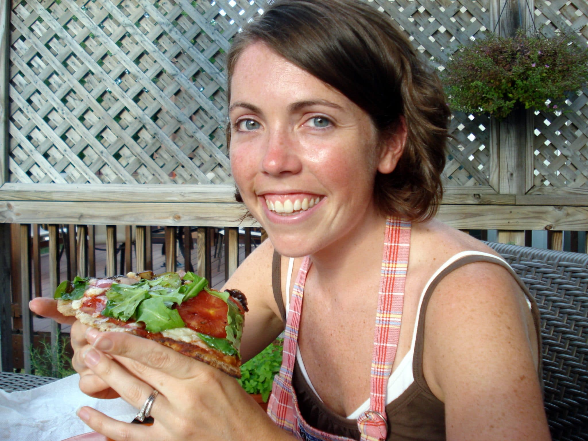 Woman enjoying slice of grilled pizza