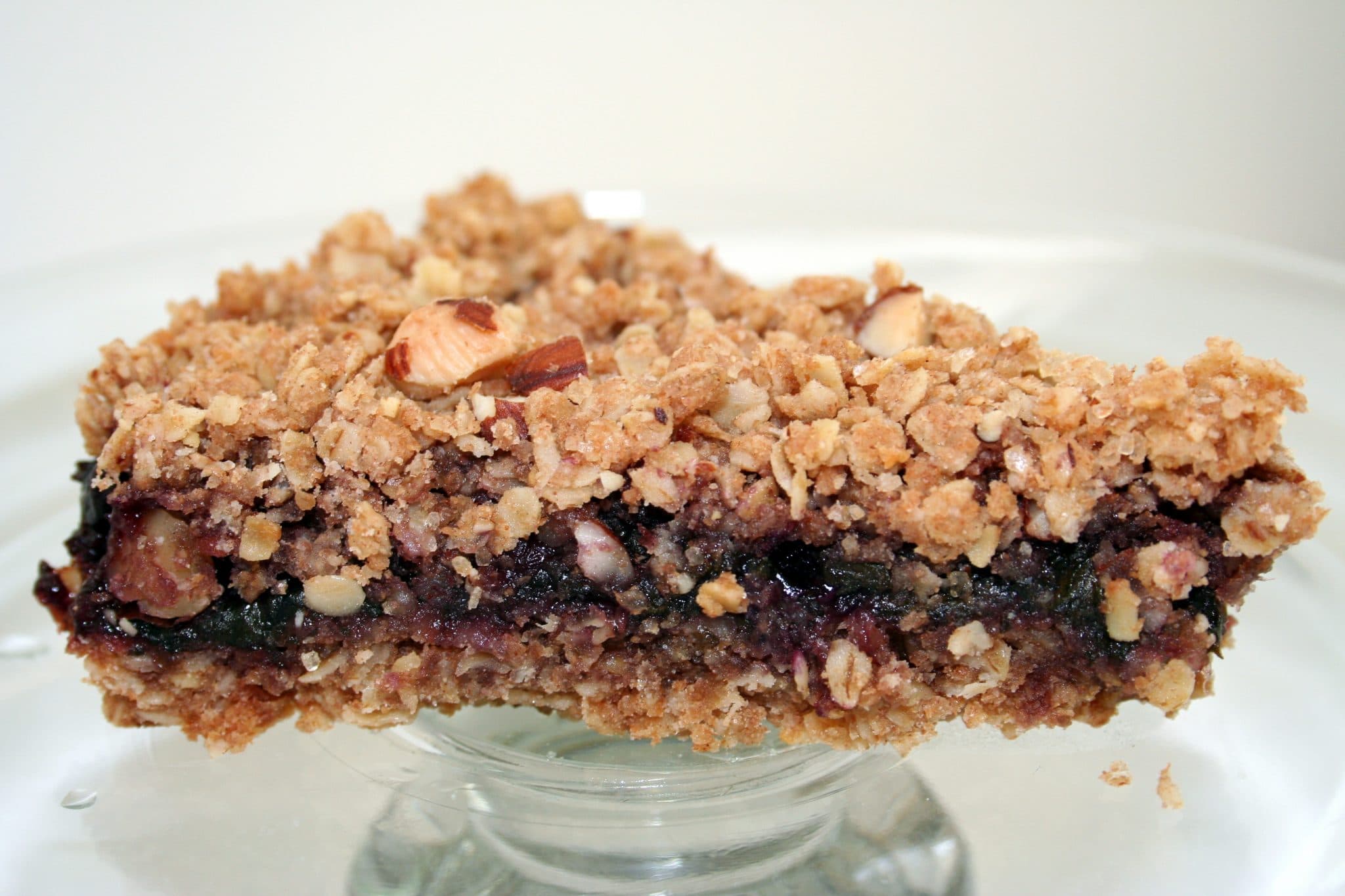 Vegan Blueberry Crumble Bars with Spinach on a plat, cut in half to show filling