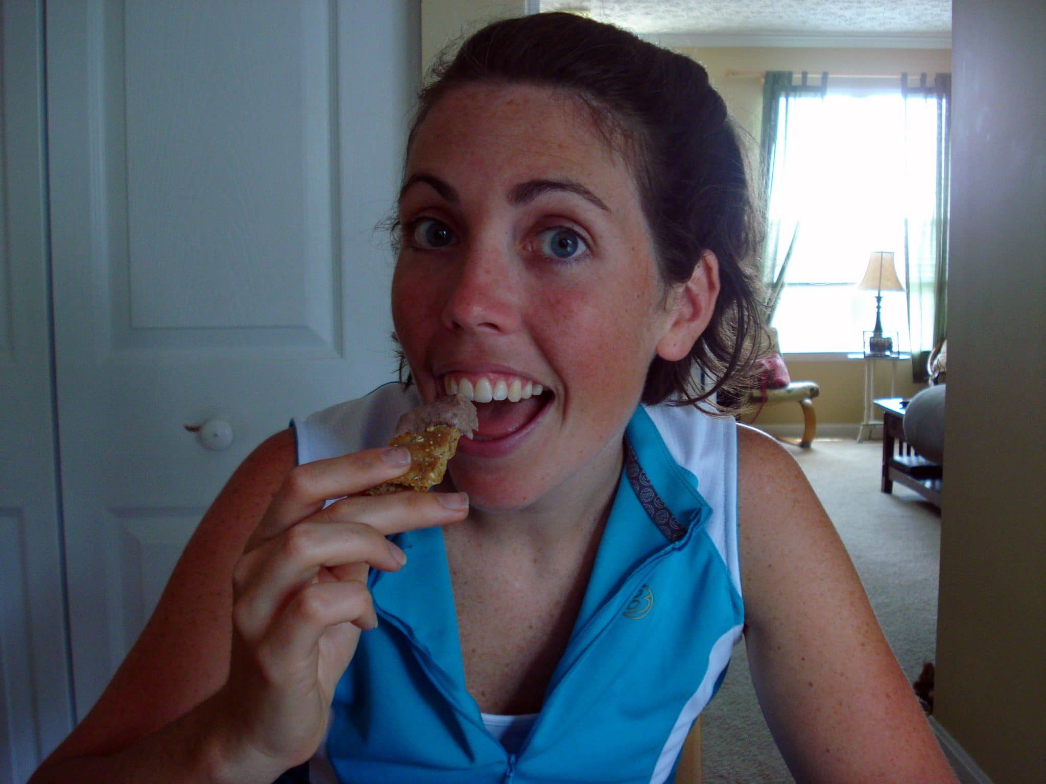 Woman eating cracker with black bean hummus