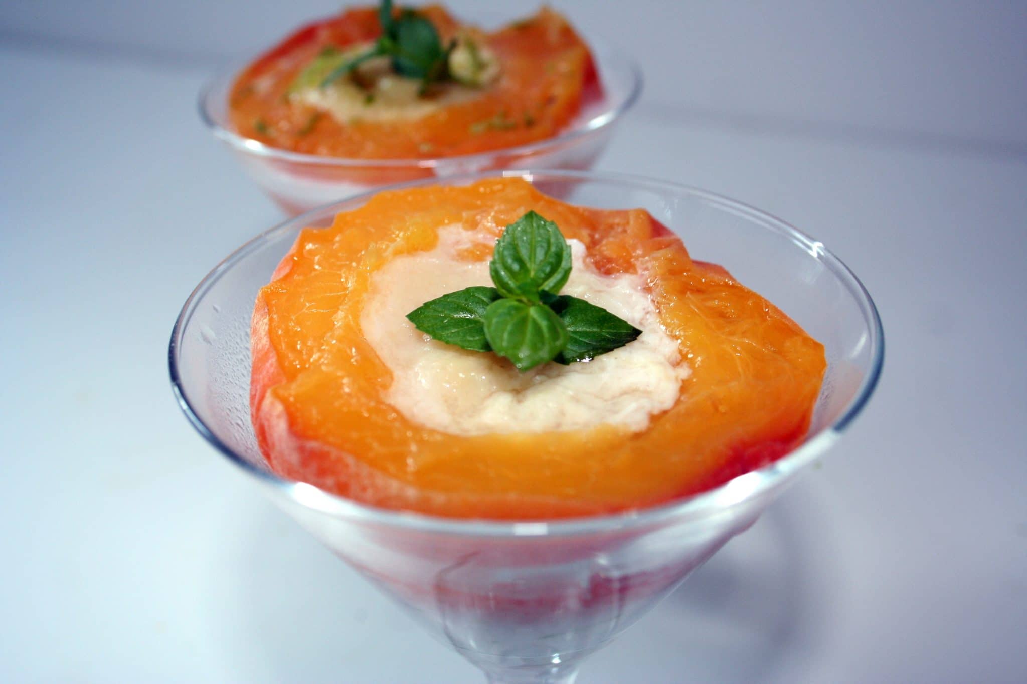 Close up of steamed peaches with custard in martini glass
