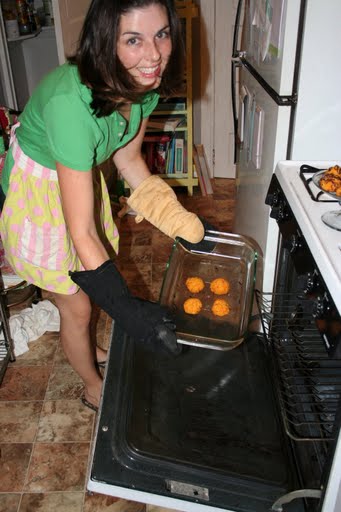 Woman placing muffin tin into over