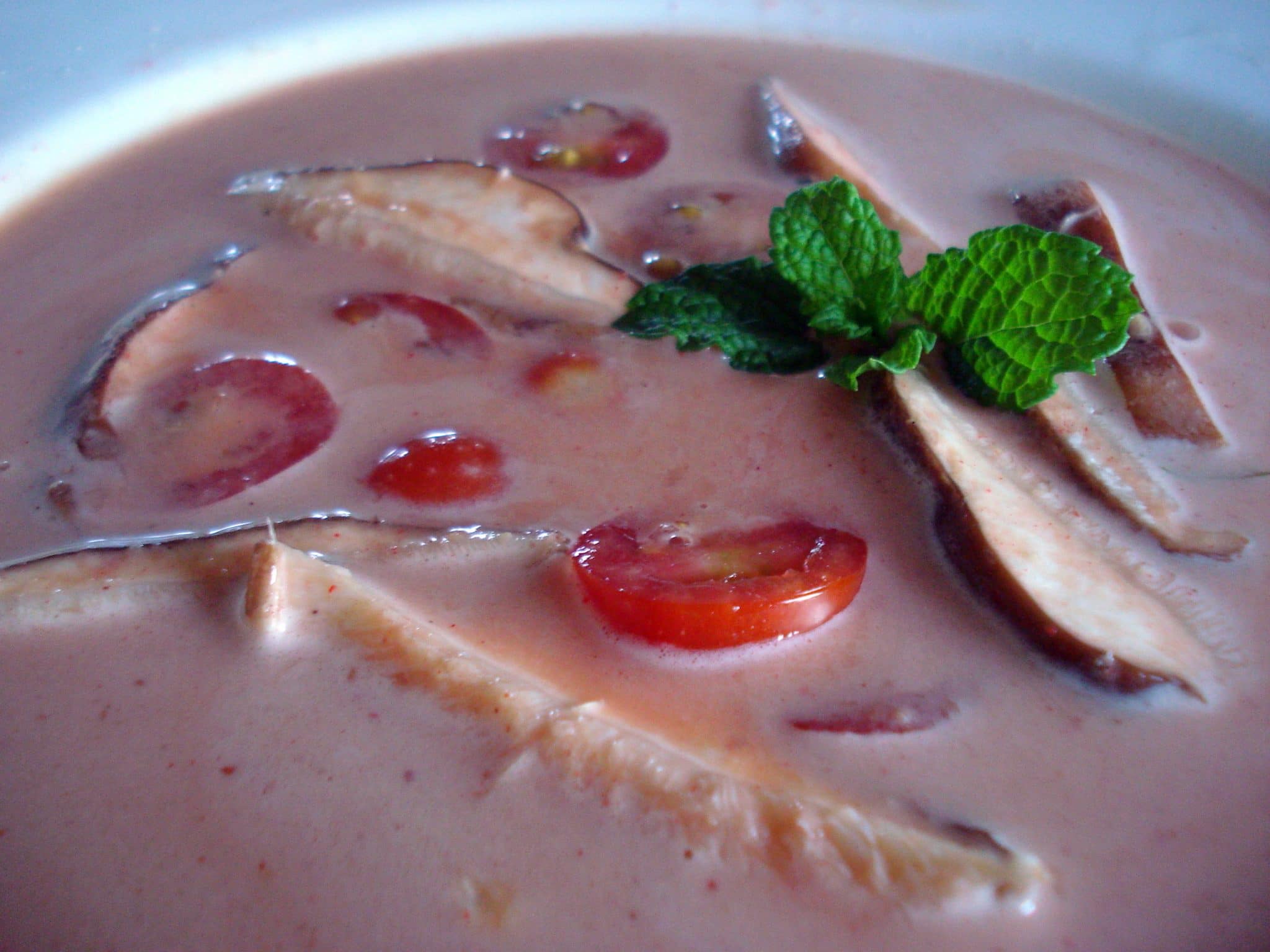 Bowl of raw curry soup with mushrooms and tomatoes