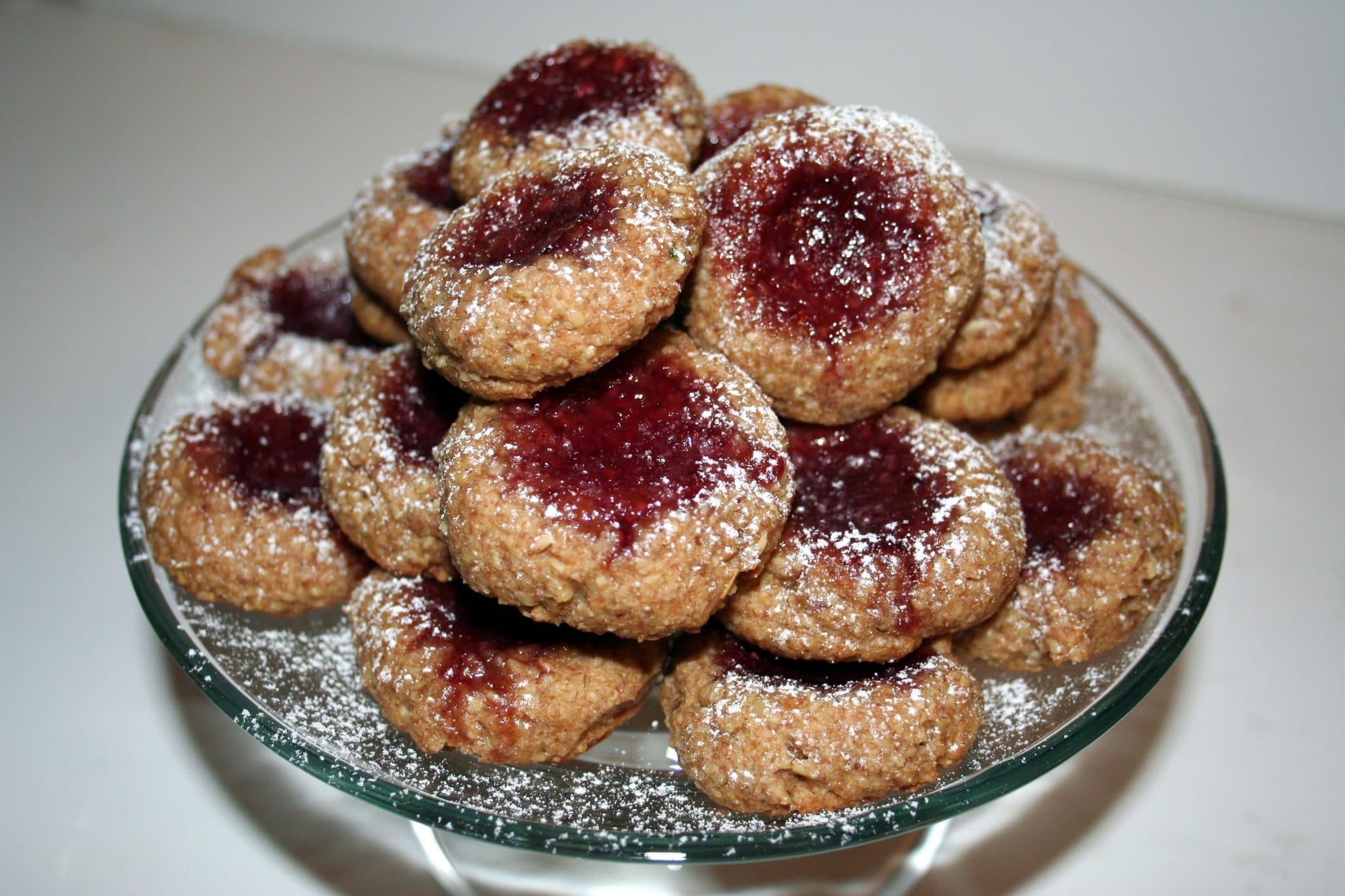 Vegan Thumbprint Cookies on a plate with powdered sugar
