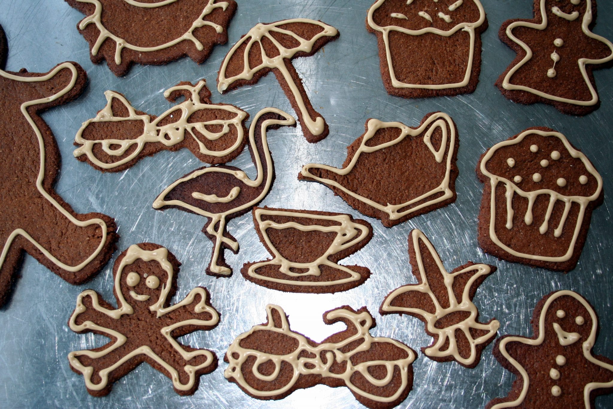 Decorated gingerbread cookies in various shapes on baking sheet