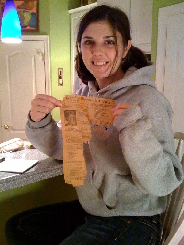 Woman holding old newspaper recipe share, "Happiness is a Warm Cookie"