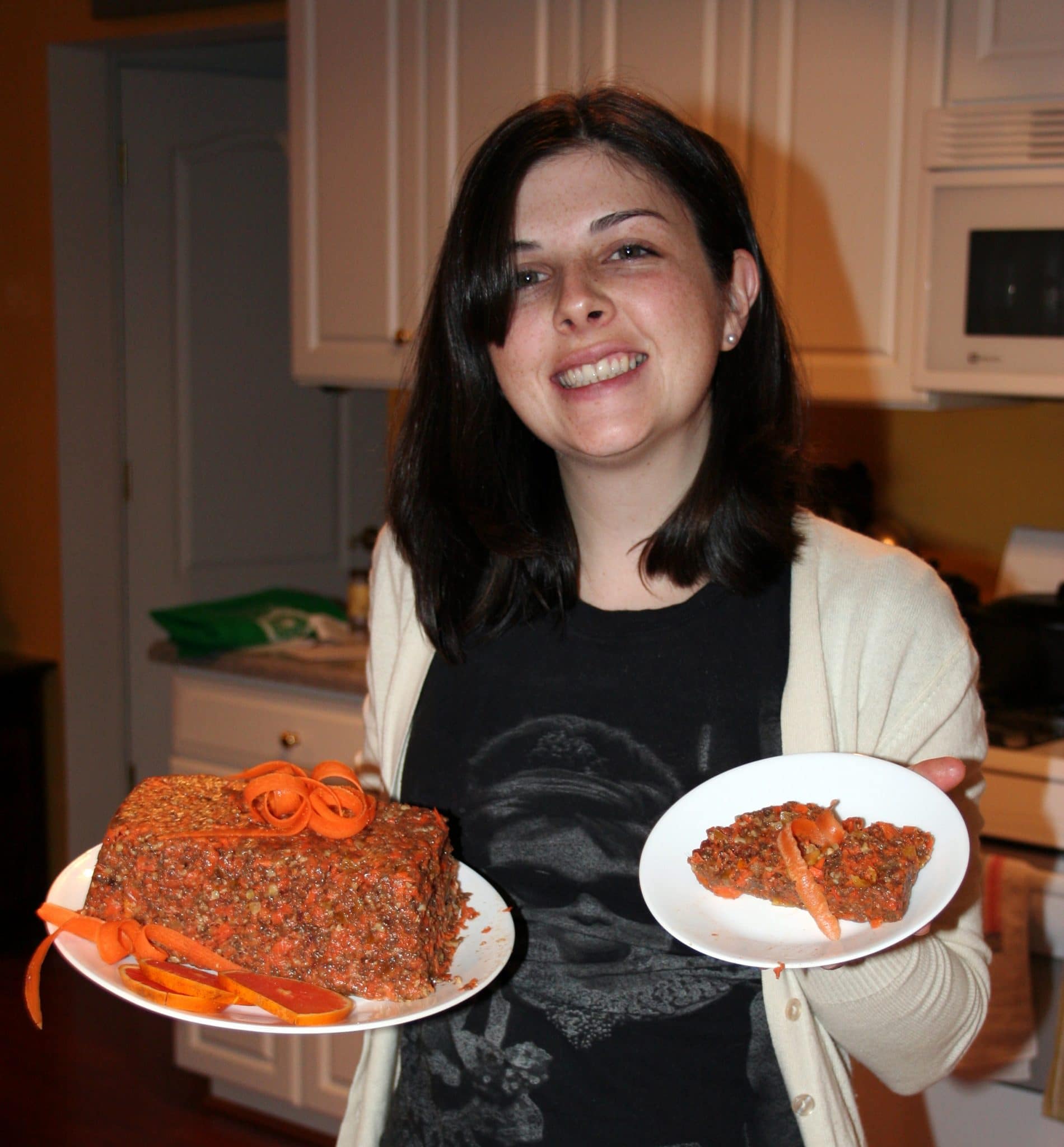 Christine holding Vegan Raw Chia-Carrot Cake in one hand, and a slice of carrot cake in the other
