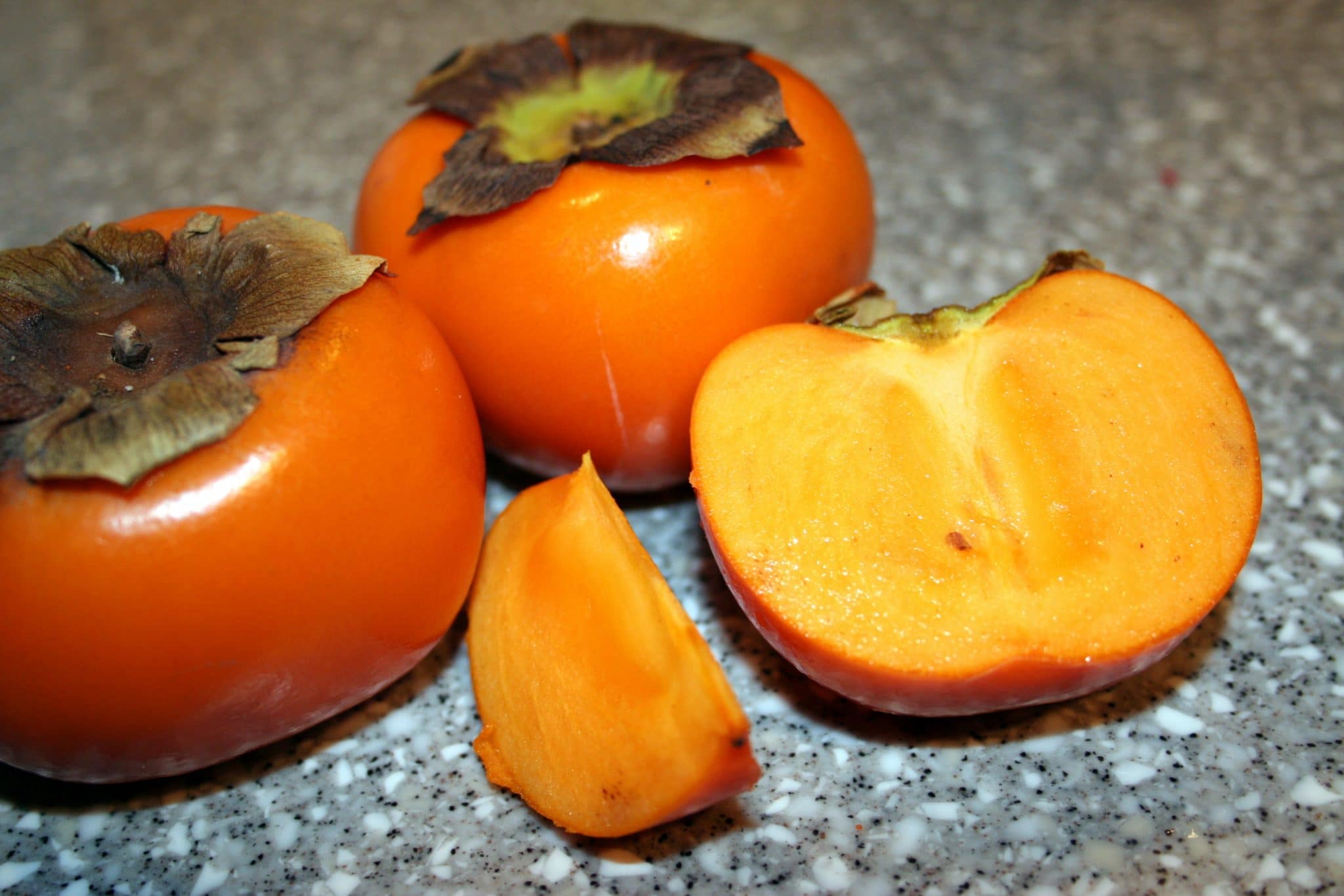 2 persimmon on kitchen counter