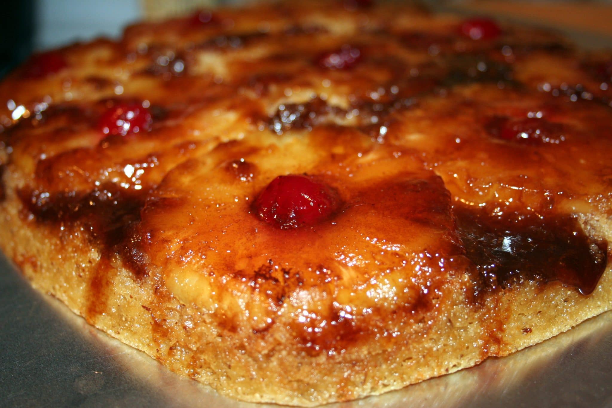 Close up of hit, grilled pineapples with a cherry in the middle