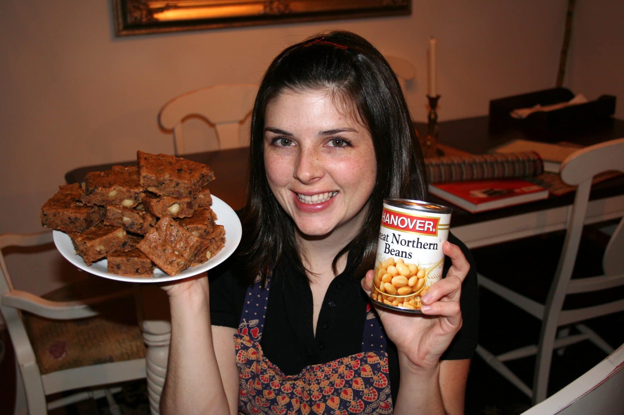 Christine holding plate of vegan white-bean blondies and can of white beans