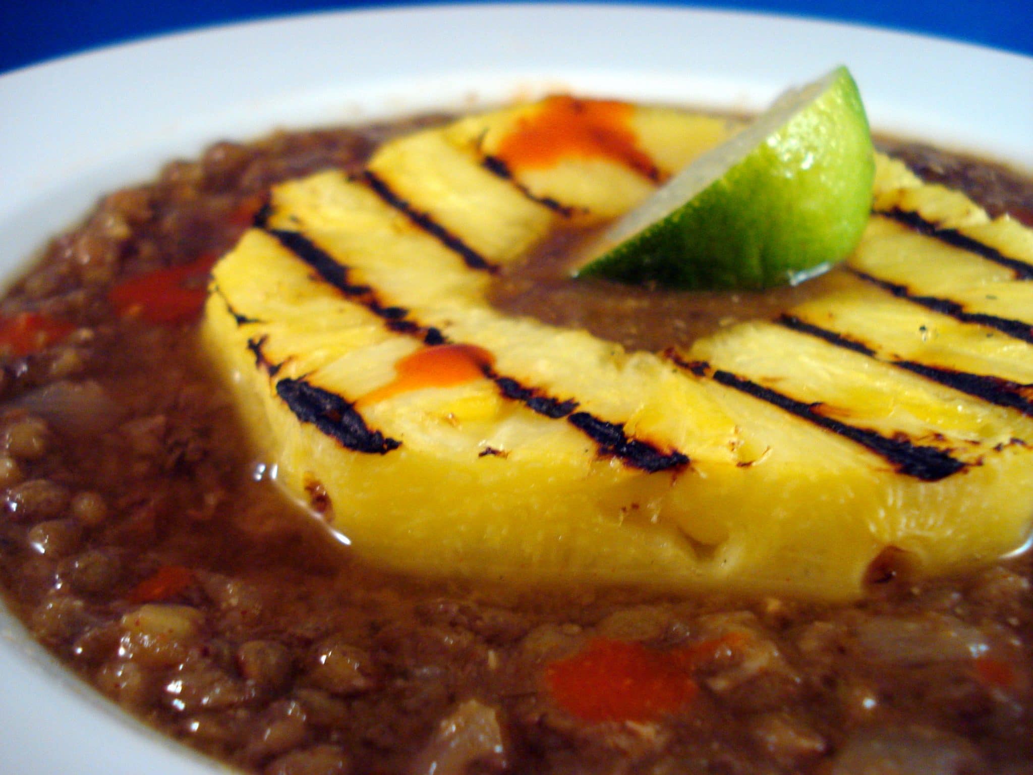 Close up of vegan lentil soup with grilled pineapple on top