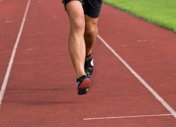 Man's legs running on track