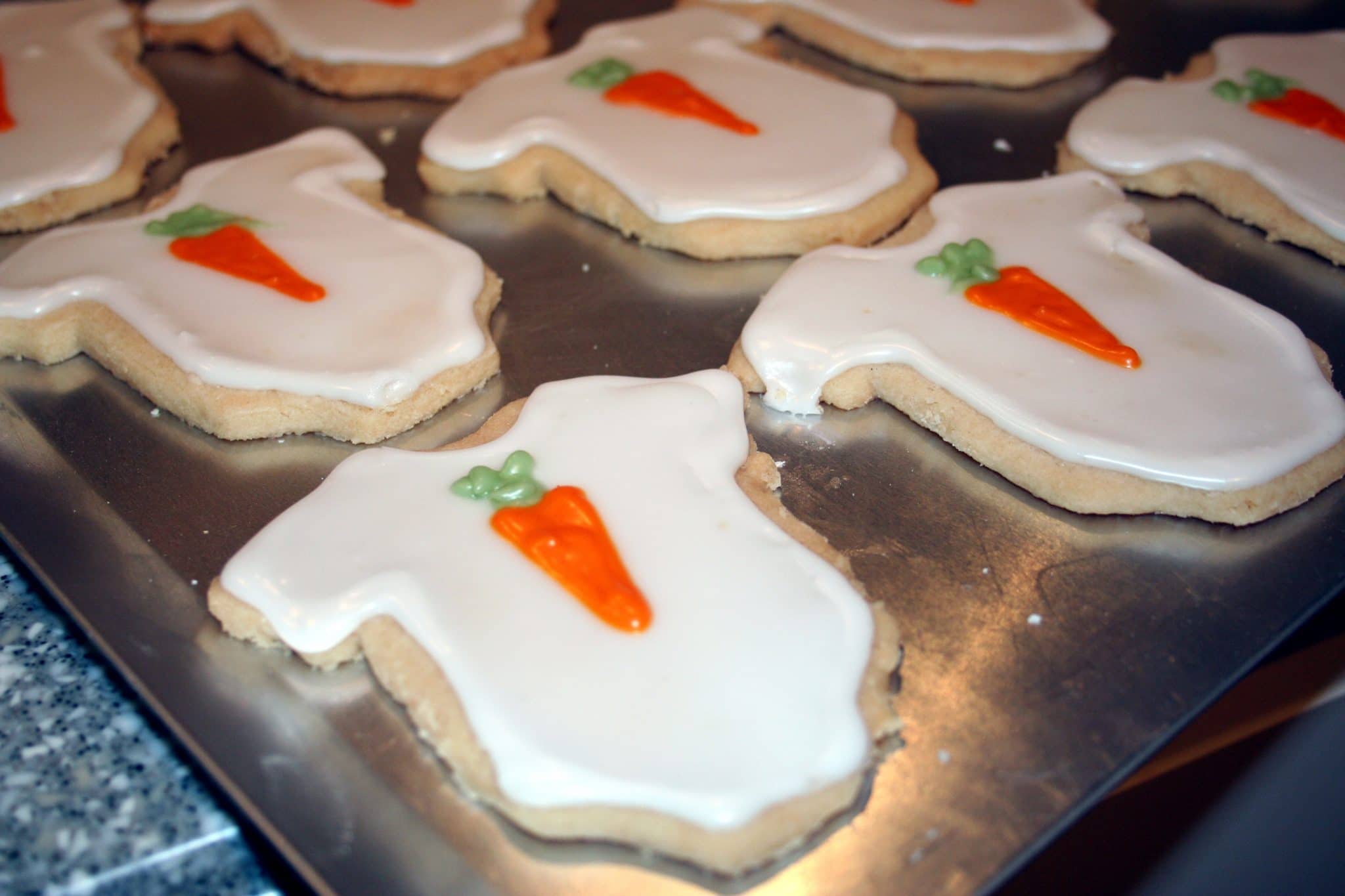 Cooling rack of onesie carrot cookies for baby shower