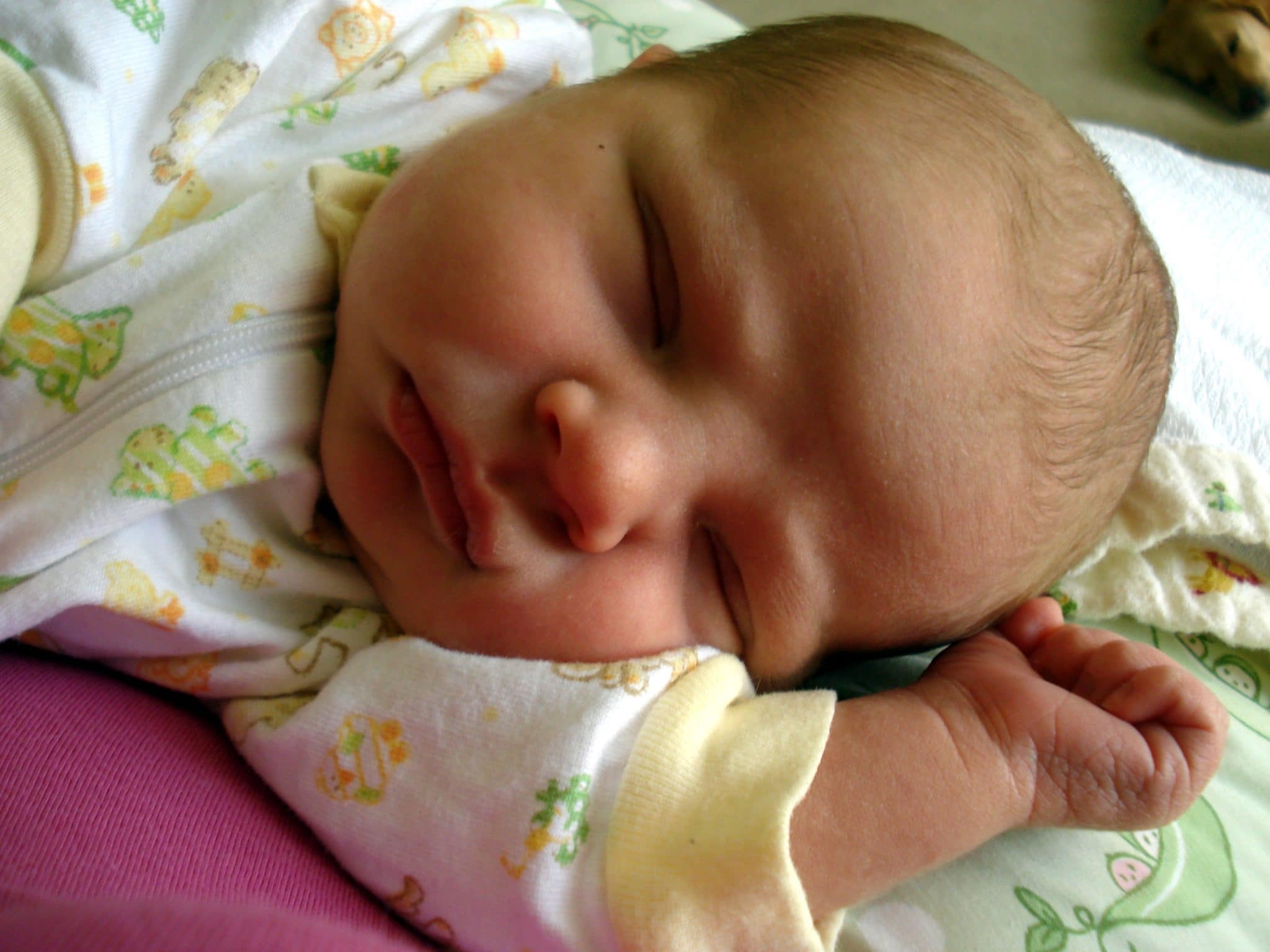 Newborn baby laying on right side