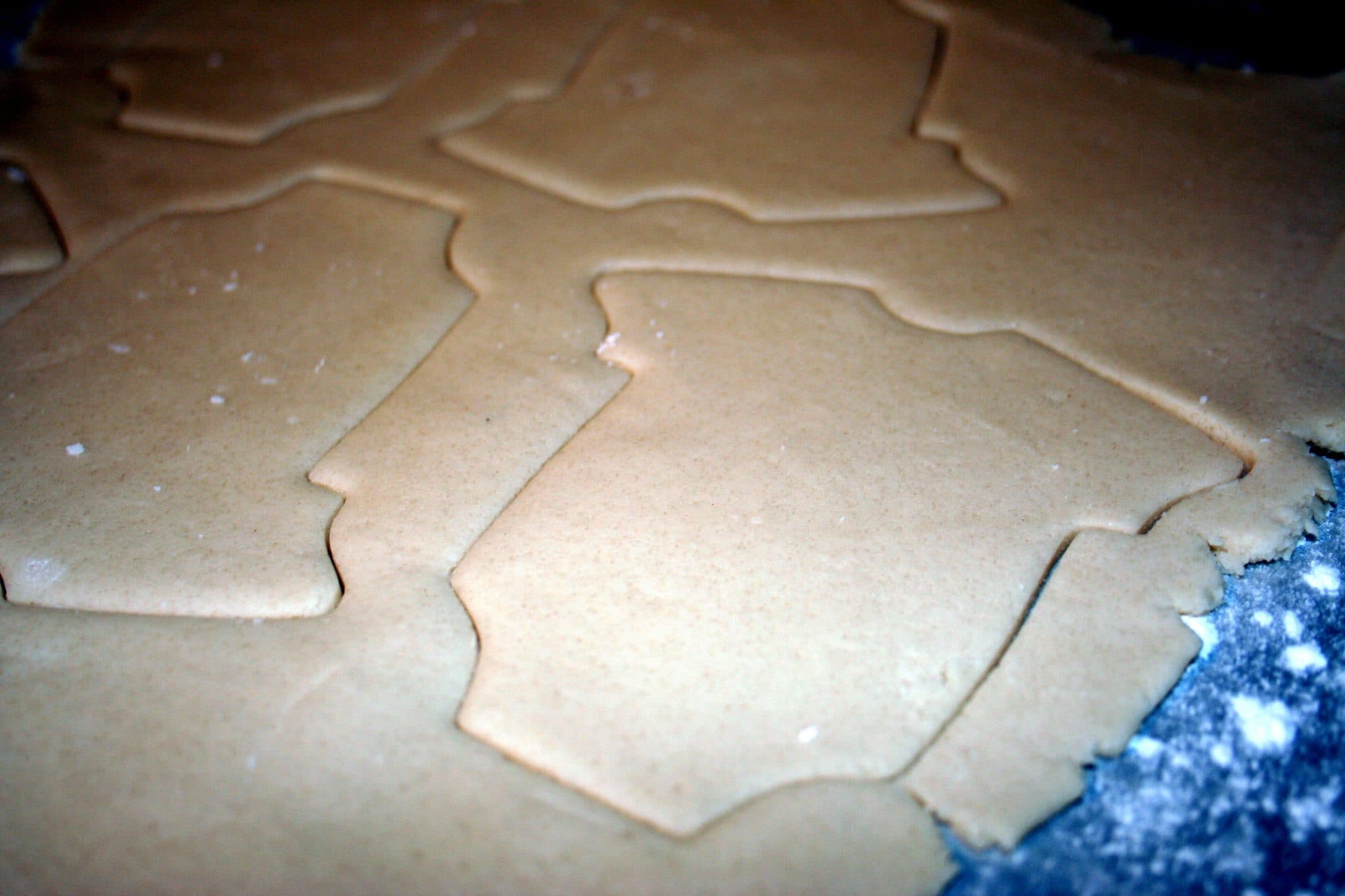 Cookies being cut by cookie cutters