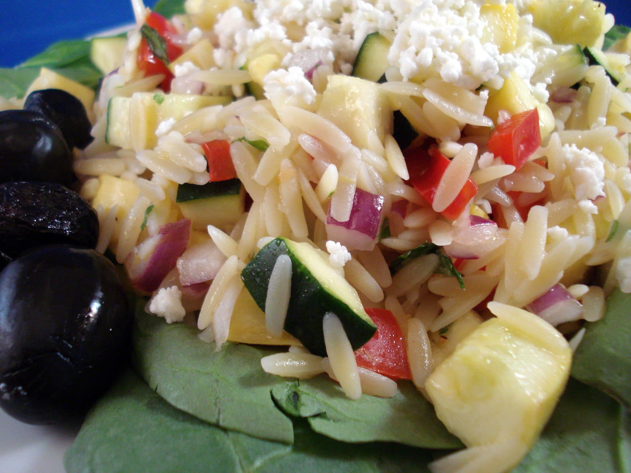 Baby spinach, olives and zucchini topped with orzo