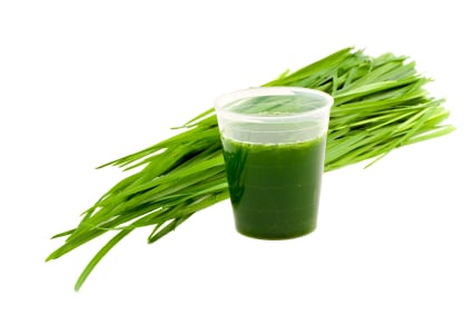 Glass of green juice with wheatgrass
