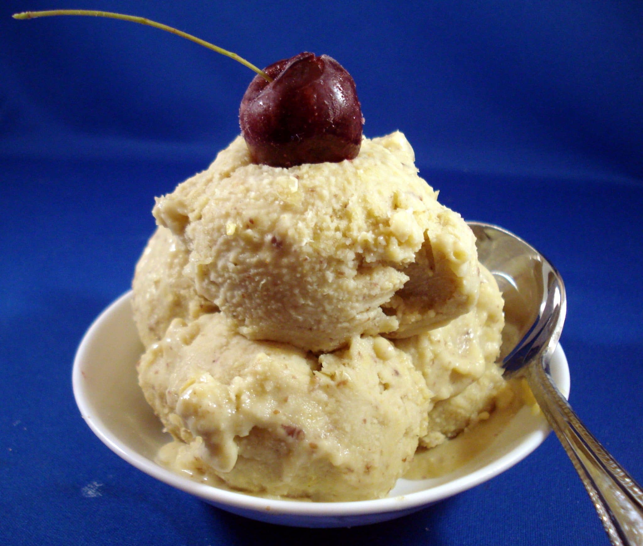 bowl of ice cream with cherry on top and spoon
