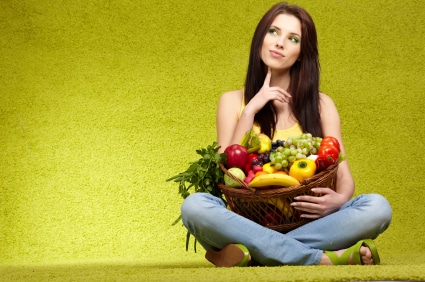 Girl ponders life while holding basket of fruit