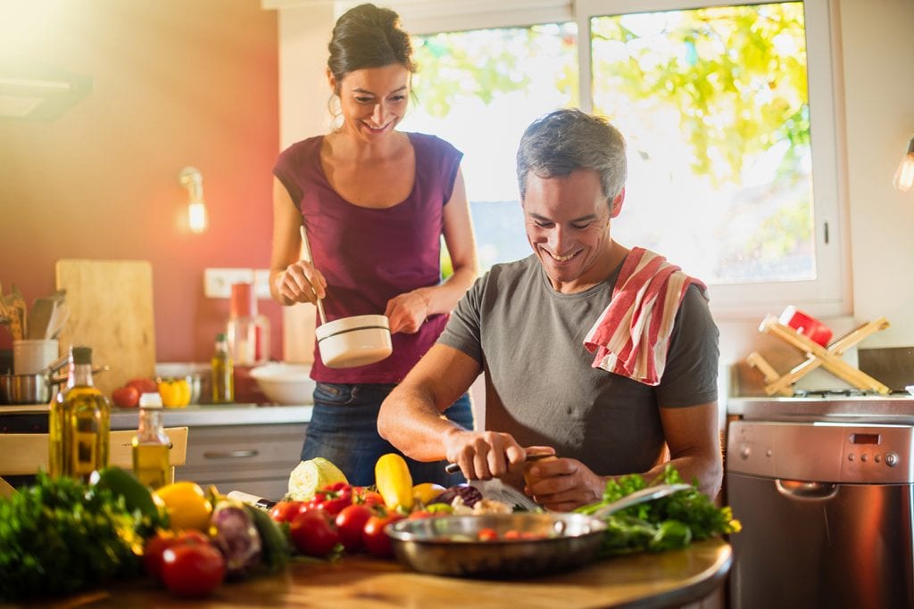 Couple preparing dinner of vegetables at the table