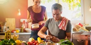 Couple preparing dinner of vegetables at the table