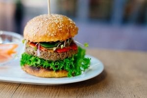 Veggie Burger on a bun with lettuce and tomato, sitting on a place