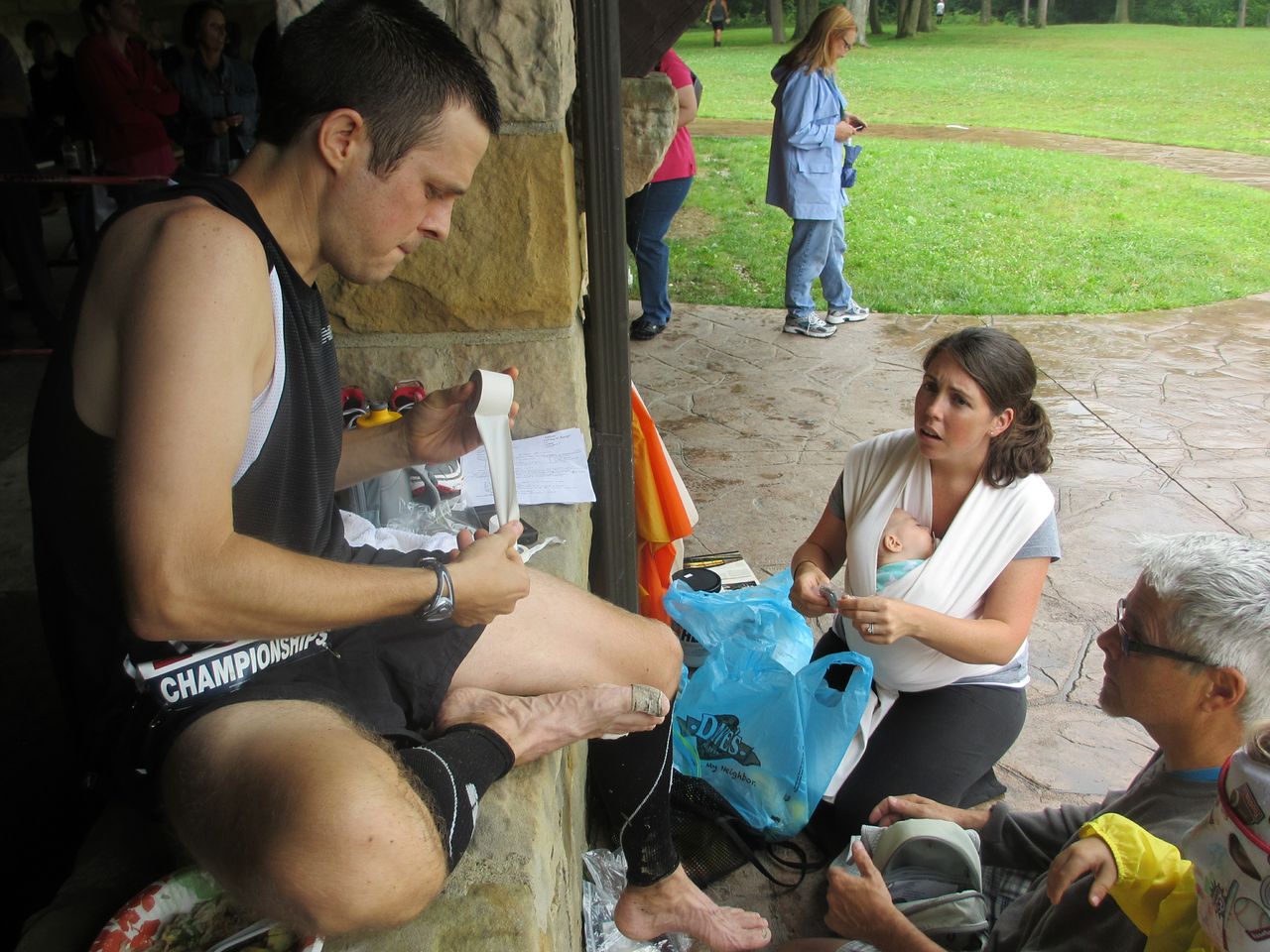 Matt at aid station, placing bandage on foot