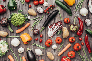 Wooden table with fresh colorful vegetables placed on top of it