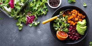 Salad Ingredients in a bowl and artfully scattered around table.